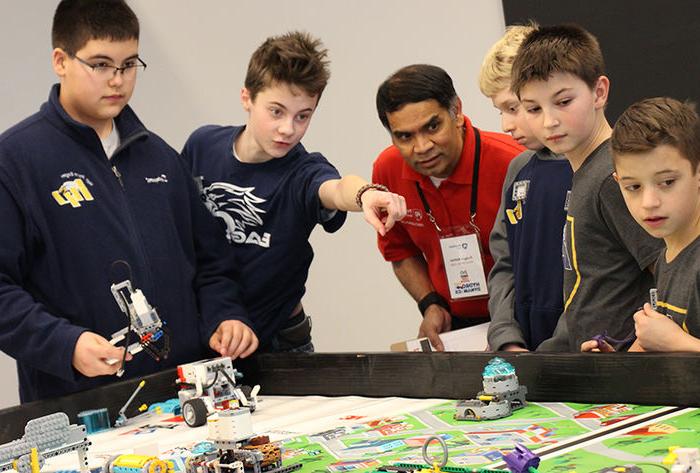 Dr. Rungun Nathan listens to a team's explanation of their robot's programming