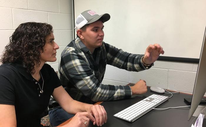 Wyatt Ritchie shows work on computer to Marietta Scanlon