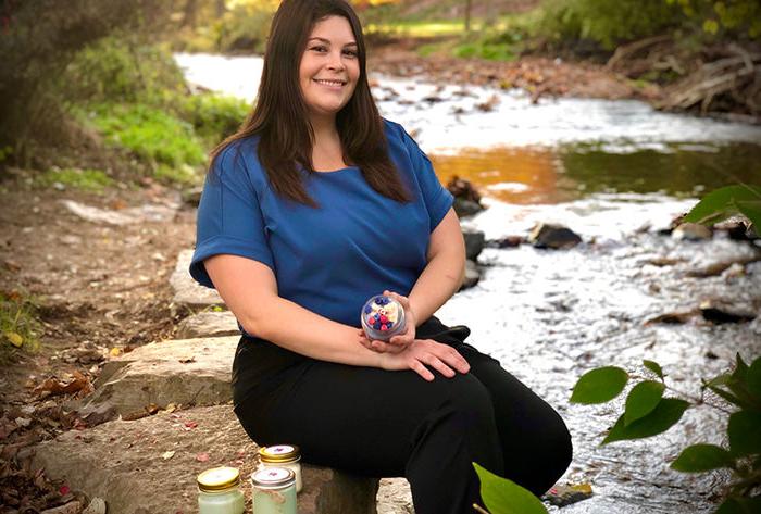 Corina Piller poses with her soy wax candle.