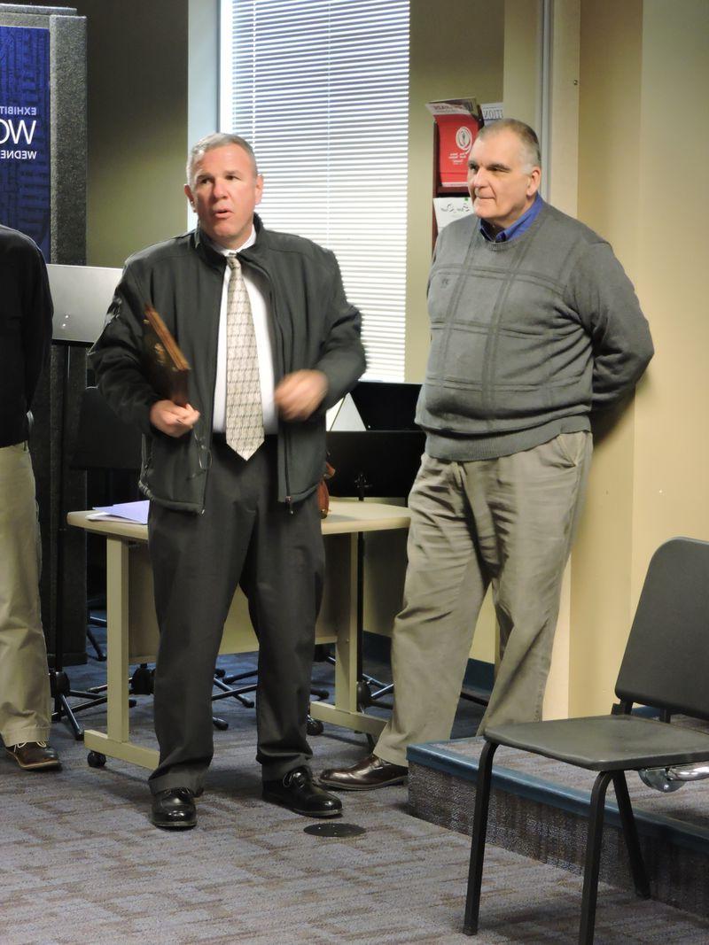 Officer Bill receives a plaque from a colleague