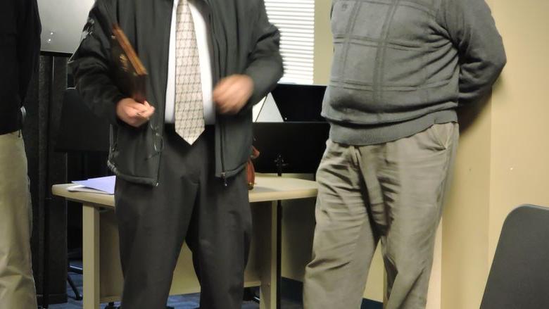Officer Bill receives a plaque from a colleague