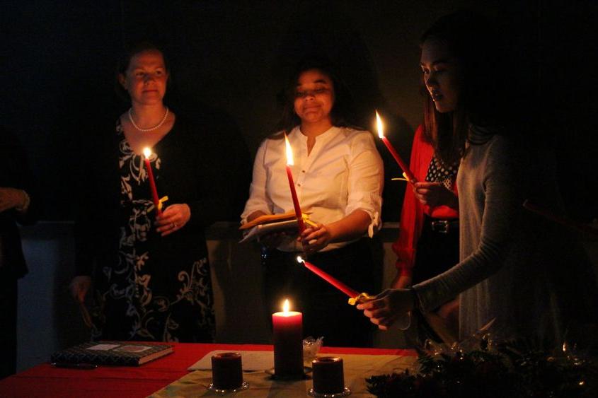 Students light a candle during the induction ceremony for Sigma Delta Pi